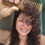 Shana combing curly hair with natural sandalwood comb.